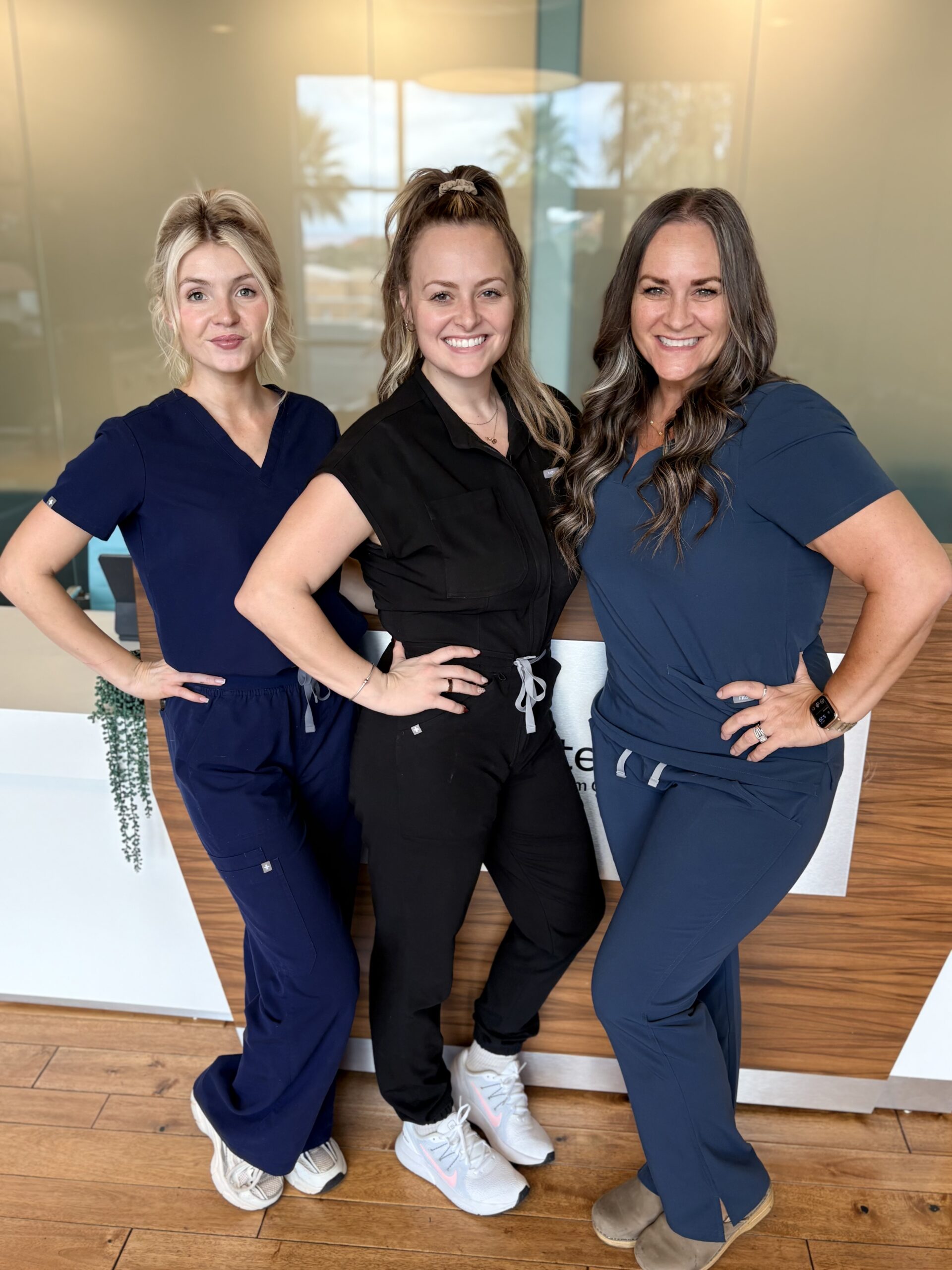 Three clinic team members standing together in the reception area